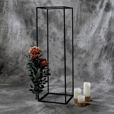 Black geometric stand with an acrylic topper used for displaying flowers and candles.
