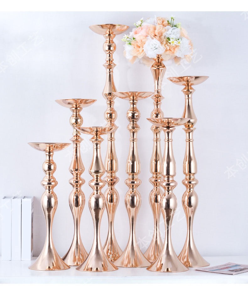 Elegant gold floral stands of varying heights used as wedding decor.