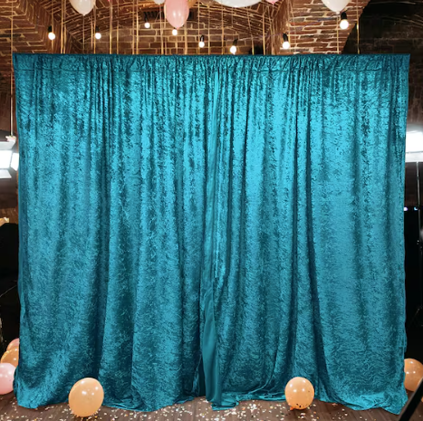 Dark teal velvet backdrop setup at an event, creating an elegant and luxurious ambiance.
