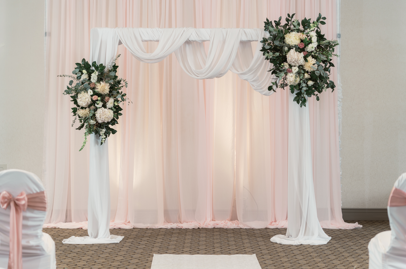 Elegant wooden arch setup as a backdrop for an outdoor wedding event.