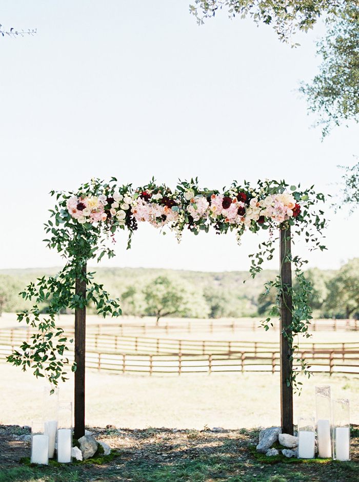 Elegant wooden arch setup as a backdrop for an outdoor wedding event.
