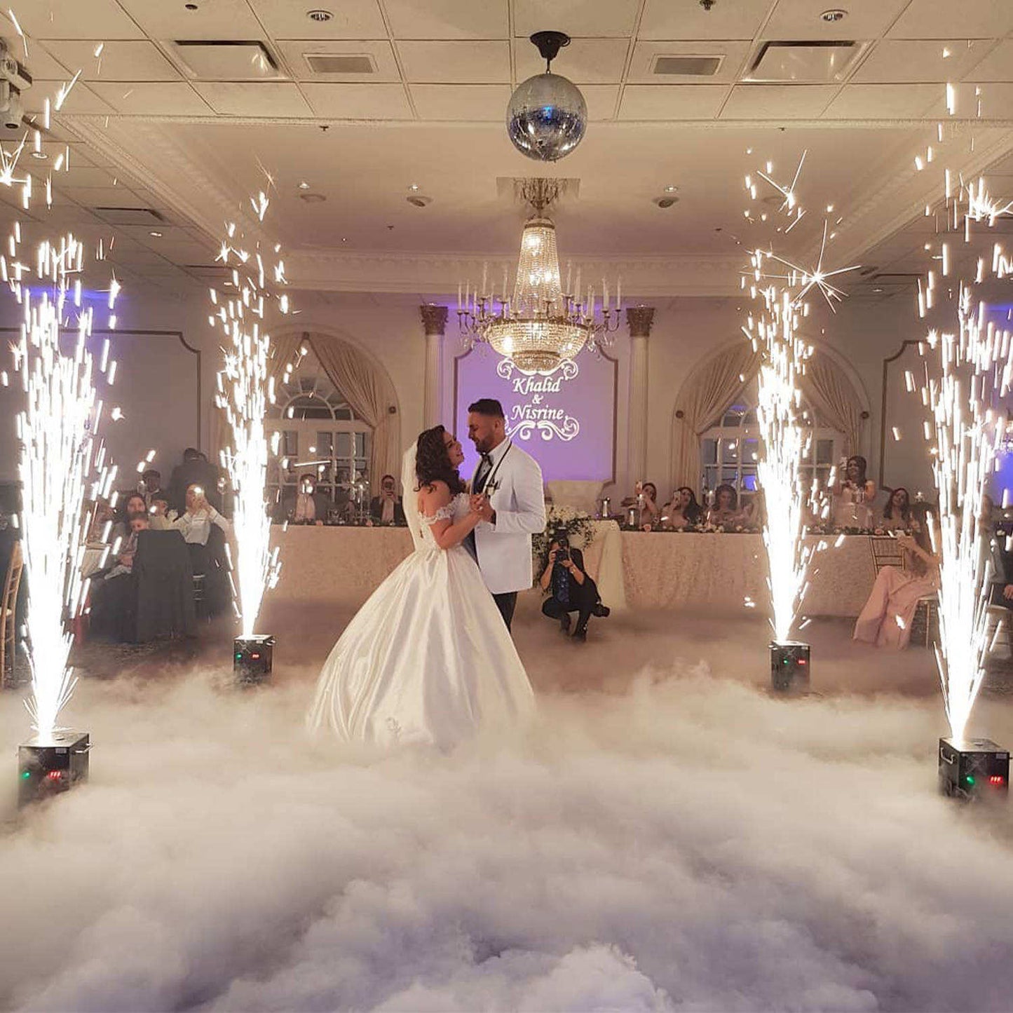 Bride and groom dancing on a fog-covered dance floor created by a low dry ice fog machine.
