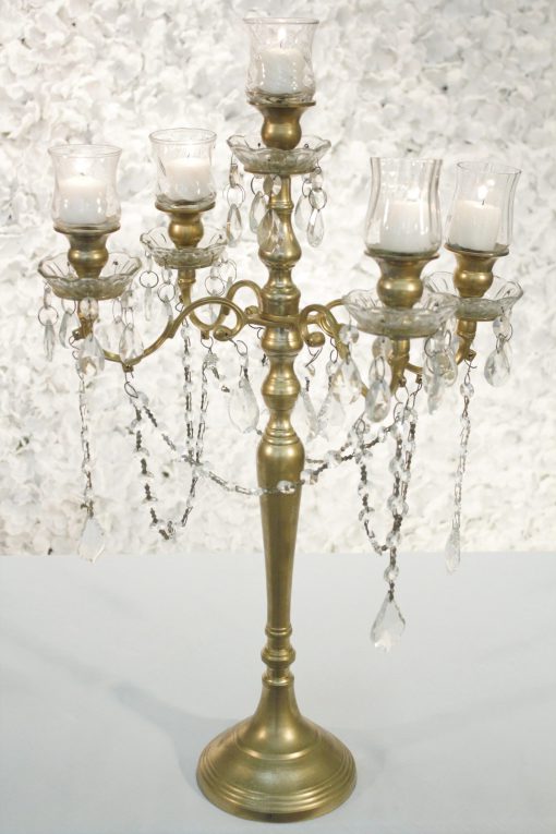 Gold candelabra with crystal draping and votive candle holders.