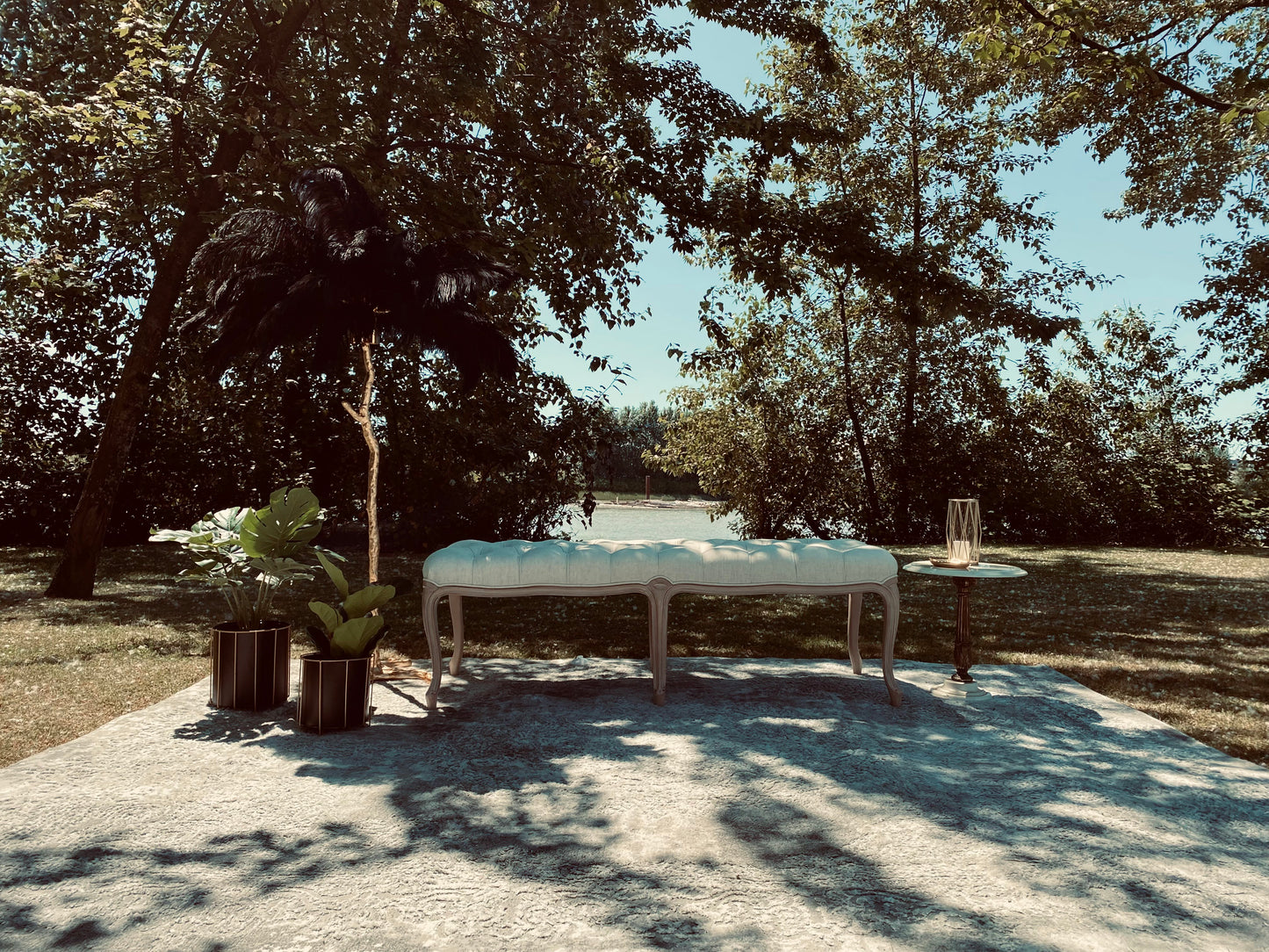 Antique Cream Louis Bench in a serene garden setting.
