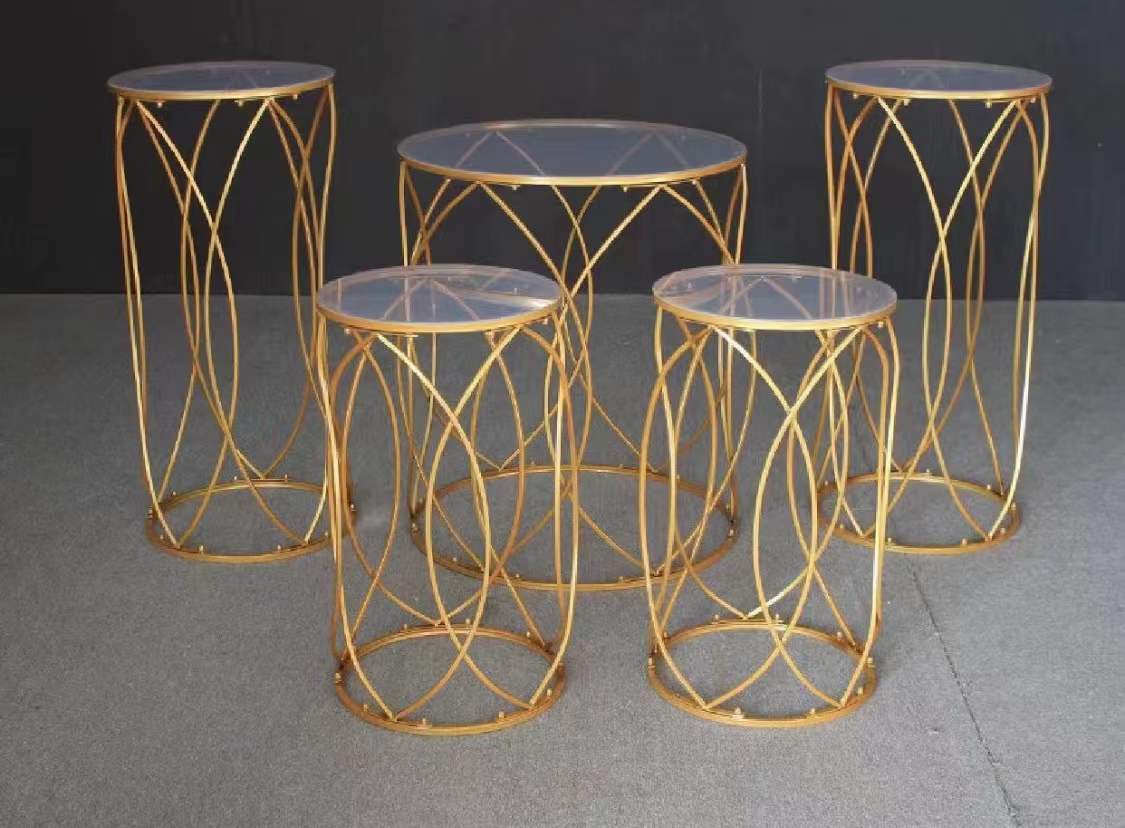 Set of deluxe gold dessert stands displaying cakes and floral arrangements.