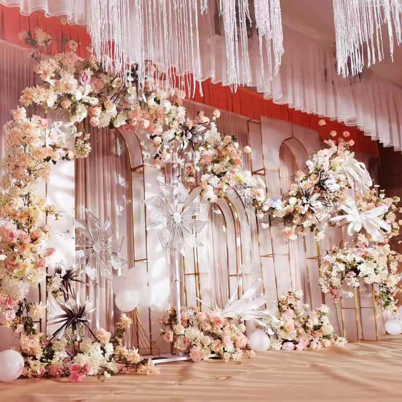Elegant wedding setup with a Grande Lancet Arch decorated with white and pink flowers