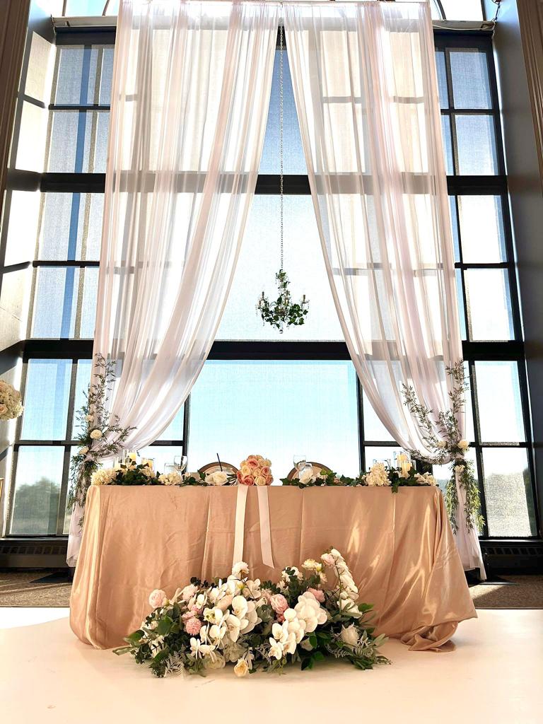 Elegant long silk floral arrangement in front of a window backdrop for a wedding." Image 2: "Long silk floral arrangement with customizable colors for event decor."