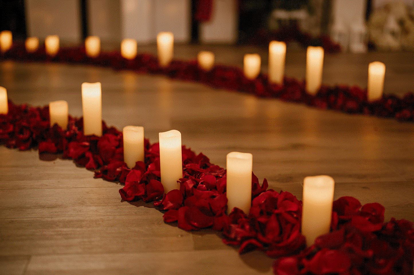 Battery operated block candles lining an aisle with rose petals for an event.