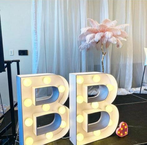 Large illuminated marquee letters BB at a glamorous event setup