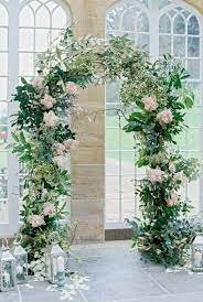 Elegant white metal arch used as a backdrop for an outdoor garden event.