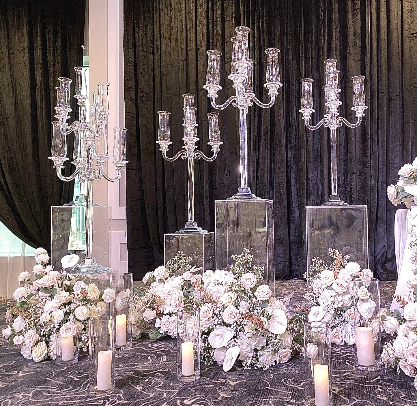 Elegant glass candelabra centerpiece with candles and floral decorations for a wedding.