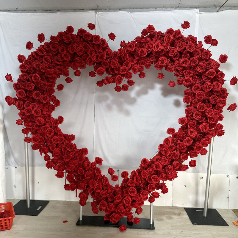 Heart-shaped arch decorated with vibrant red silk flowers, perfect for weddings and romantic events