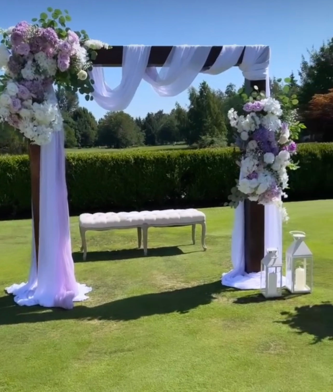 Elegant wooden arch setup as a backdrop for an outdoor wedding event.