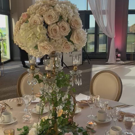 Silk faux rose and hydrangea arrangement as a centerpiece on an elegantly set table.