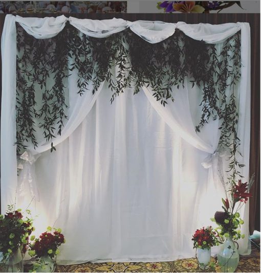 Elegant draping backdrop in blue lighting for an event.