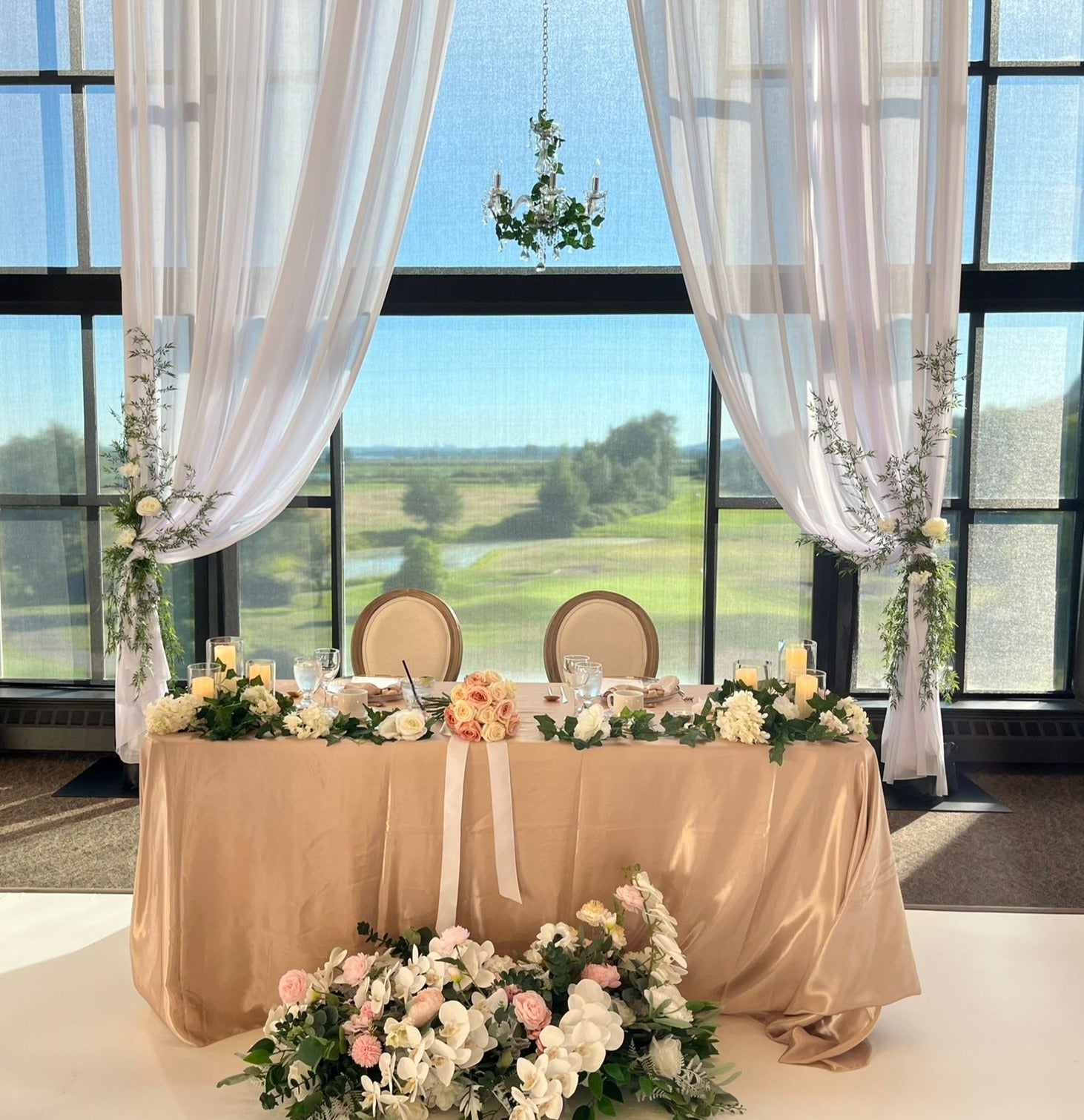 Silk faux long floral arrangement with roses and hydrangeas adorning a beautifully set table.