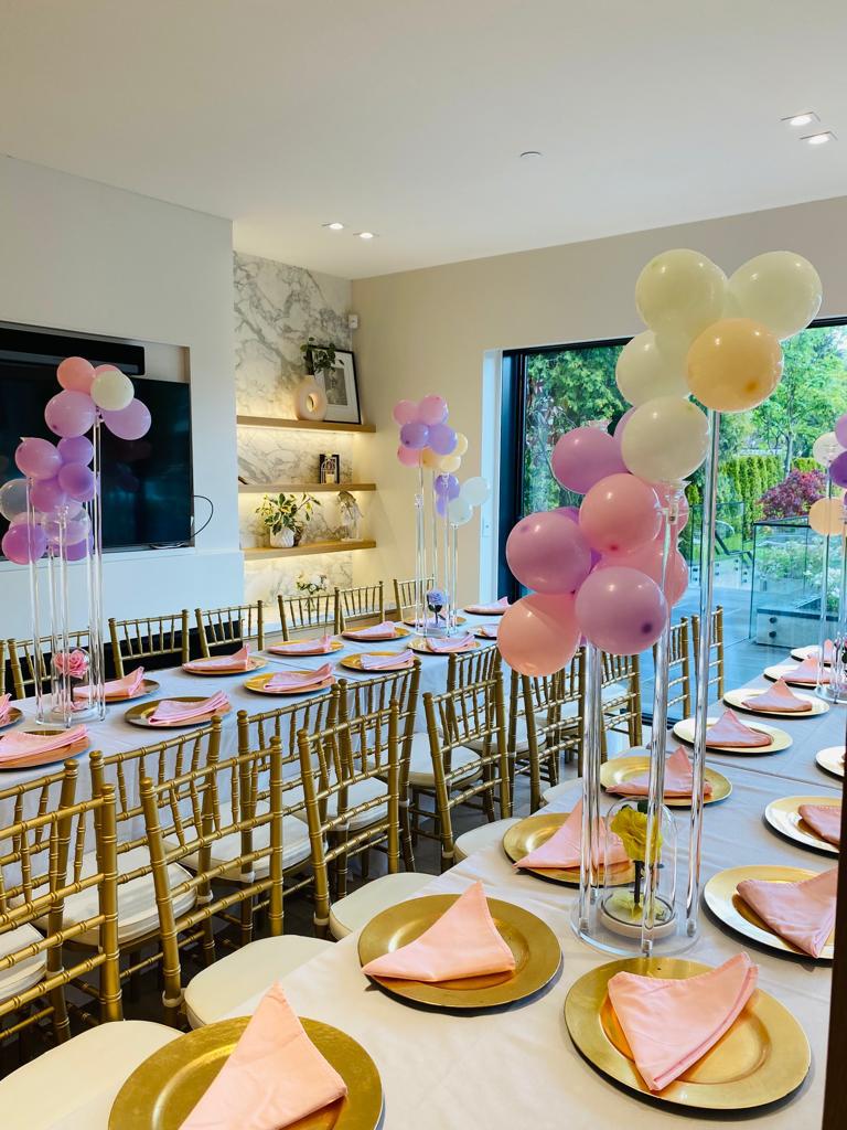 Pastel balloon setup with custom name for a birthday party.