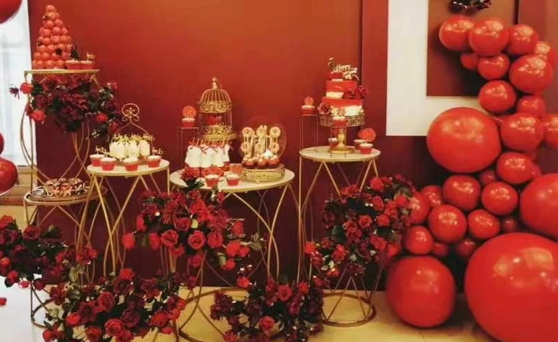 Set of 5 Gold Stands elegantly displaying desserts and flowers at an event.