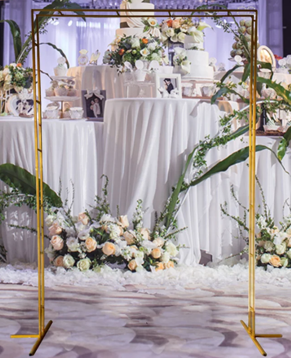 Golden rectangular metal frame decorated with white flowers and greenery, ideal for event decor.